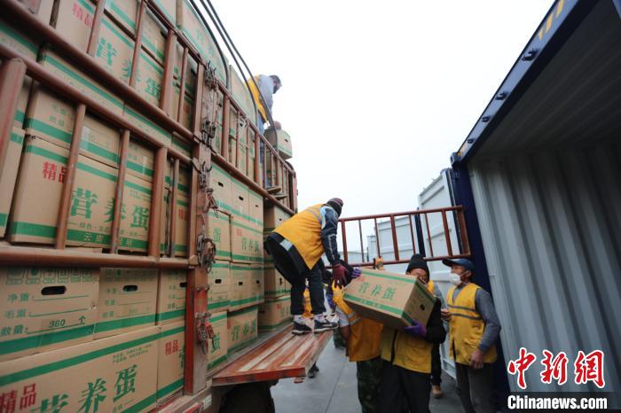 圖為鐵路裝卸作業(yè)人員正在將云南特色農(nóng)產(chǎn)品裝入集裝箱?！詈?攝