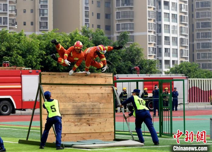 新消防員進(jìn)行消防障礙接力操展示?！⒅铱?攝