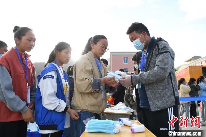 7月7日，考生在拉薩三高考點(diǎn)外領(lǐng)取口罩?！『闻罾?攝