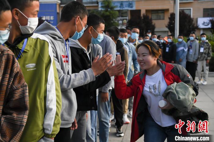 7月7日，拉薩三高考點(diǎn)外，領(lǐng)隊老師與考生擊掌鼓勁加油?！『闻罾?攝