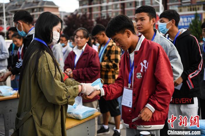 7月7日，考生在拉薩三高考點(diǎn)外測量體溫?！『闻罾?攝